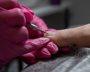 The master makes hardware pedicures to the client. Cuticle treatment. 