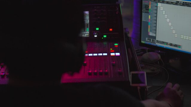 Sound mixing console in a nightclub concert with violet light.
