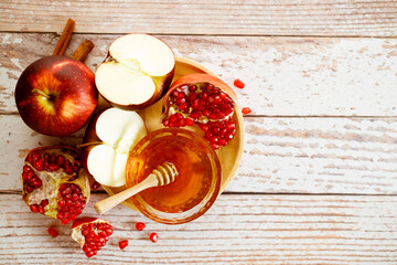 Apples, pomegranate and honey on a wooden background. Rosh Hashanah (jewish holiday) concept..