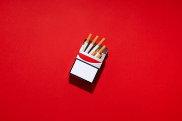 Concept of harm of smoking, pack of cigarettes on red background