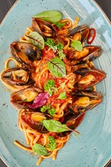 Pasta with mussels with red sauce. Food from the chef in a restaurant or cafe.