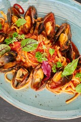 Pasta with mussels with red sauce. Food from the chef in a restaurant or cafe.