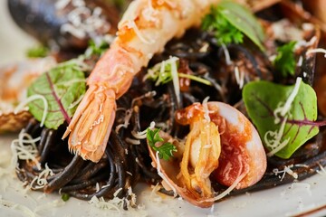 Black pasta with mussels and king shrimp. Food from the chef in a restaurant or cafe.