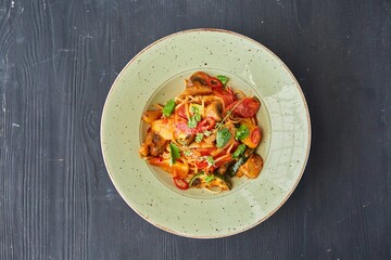 Pasta with chicken, zucchini and mushrooms with red sauce. Food from the chef in a restaurant or cafe.