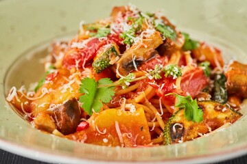 Pasta with chicken, zucchini and mushrooms with red sauce. Food from the chef in a restaurant or cafe.