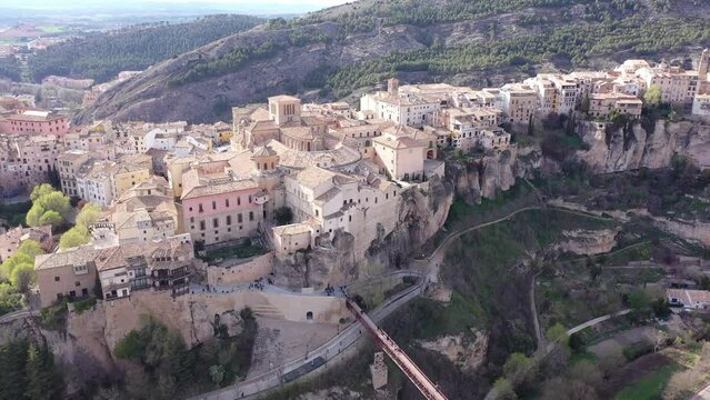 Picturesque view of historic district of Cuenca city on steep spur above deep gorge on sunny spring day, Spain