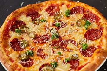 Pasta with salami, olives and pineapples. Food from the chef in a restaurant or cafe.