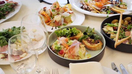 Wedding festive table with food drinks and decor. Catering service on banquet with canape snacks in restaurant or hotel. Decorated food set on birthday, wedding celebration, business conference event.