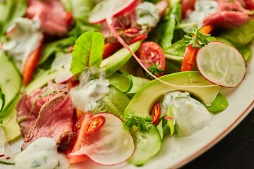 Salad of meat, vegetables and herbs. Food from the chef in a restaurant or cafe.