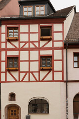 Fototapeta premium Old historic architecture in Nuremberg, Germany. Traditional European old town buildings with wooden windows, shutters and colourful pastel walls. Aesthetic summer vacation, tourism background