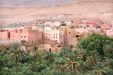Fototapeta na wymiar Aerial view of medieval town in Atlas mountains, Morocco, North Africa. Aerial view of old adobe houses and palms