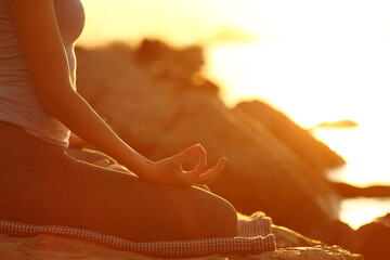 Close up of woman hand doing yoga at sunset