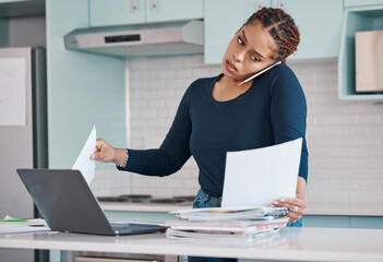 Naklejka premium Black business woman working from home in freelance, multitasking paperwork with laptop and mobile audio phone call. Internet technology in kitchen, consulting invoice documents in covid pandemic