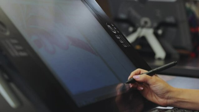 Drawing on a graphics tablet. The designer draws on a graphics tablet. Working with interactive pen display. closeup. Wallpaper production.