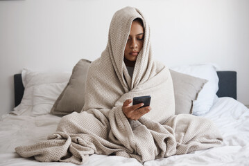 Depression, anxiety and woman texting in bed, reading online social media bullying post, feeling...