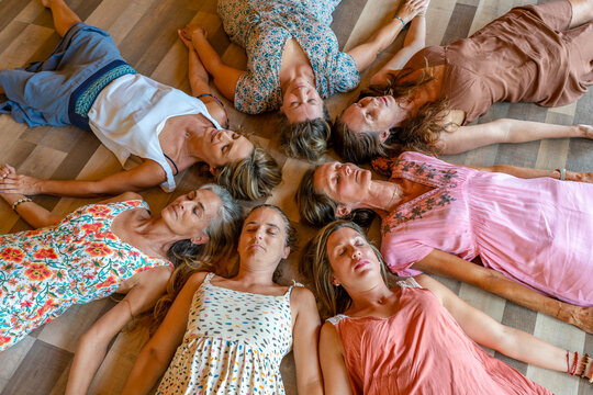 Group of friends with eyes closed lying together on floor
