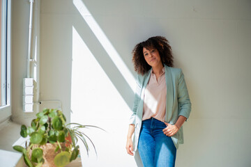 Confident mature businesswoman in front of white wall