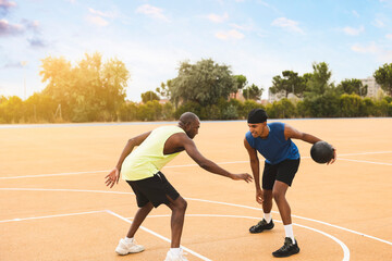 Father and son playing basketball at sports court