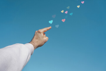 hand up in the sky touching a heart shape, love emotions in valentine's day