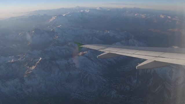 Vista aerea del la cordillera de los andes desde la ventanilla de un avion de aerolinea al atardecer