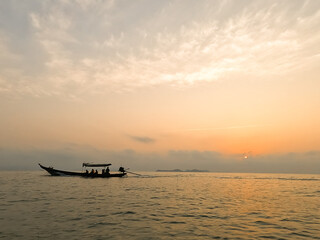 fisherman set sail small fishing boat in the morning sunrise orange light