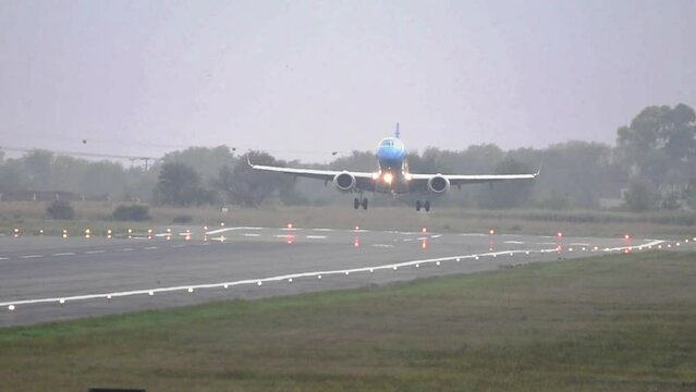 Avion de aerolinea aterrizando en la pista con mucha distorcion optica con arboles de fondo 