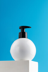 Obraz premium Mockup of a white dispenser with a cosmetic product with a place for your logo on a podium.