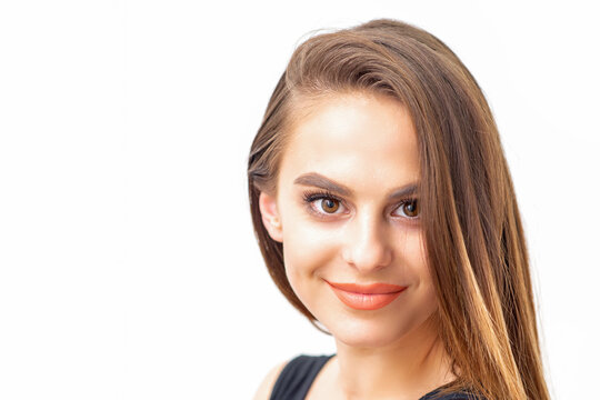 Portrait of a beautiful young caucasian smiling brunette woman with long straight hair standing and looking at the camera on white background