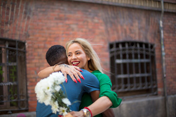 Happy multicultural couple embracing on the street