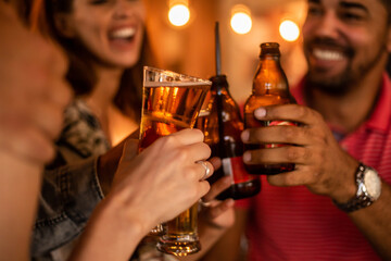 Happy young people drinking bear at pub