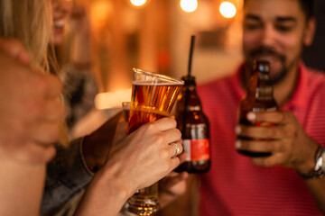 Happy young people drinking bear at pub