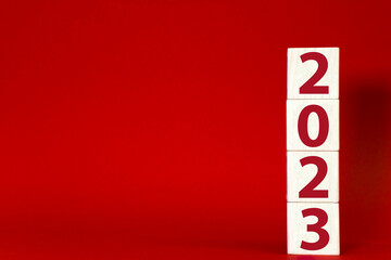 2023 on wooden block cube on red background. Christmas mock-up, template with copy space. Merry...