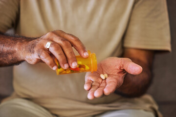 Medicine, healthcare and pills in the hands of a senior man sitting on a sofa in the retirement...