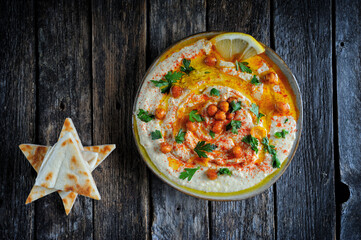 Homemade creamy hummus with sweet paprika, olive oil and fresh pita bread