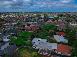 Panoramic aerial Drone view of Melbournes suburbs and CBD looking down at Houses roads and Parks Victoria Australia. Beautiful colours at Sunset