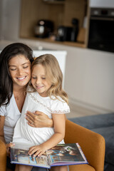 Young mother and her cute little daughter,mom is reading a book to her. Family time concept