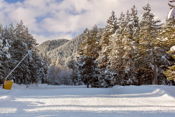 Bansko, Bulgaria, bulgarian winter ski resort panorama with groomed ski road slope and Pirin mountain peaks view