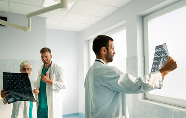 Doctors discussing patient's diagnosis looking at x-rays in a hospital