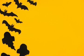 Happy Halloween! Halloween flat lay. Bats and ghosts decoration on yellow.Minimal halloween template