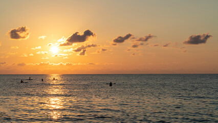 Bright sunset with large yellow sun under the sea surface.