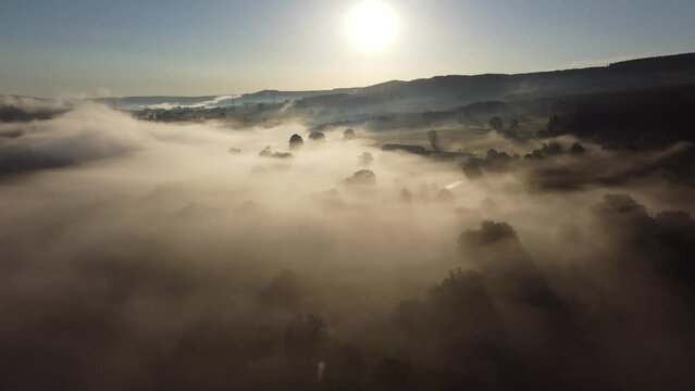 Fog in the valley of the Belgian Ardennes near Chevron, Li&egrave;ge. Aerial with beautiful sunbeams
