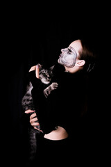 Fototapeta na wymiar Halloween cat in woman handst. Celebration and pets concept