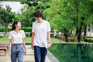 A couple walking together by the swimming pool hotel during vacation, Business outside
