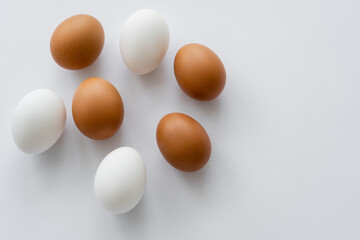 Top view of organic chicken eggs on white background.