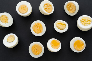 Top view of organic boiled eggs on black background.