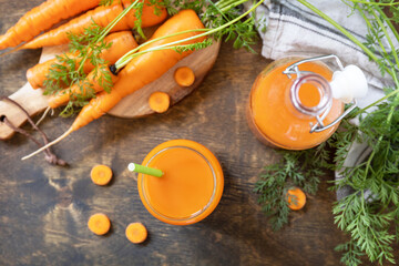 Healthy food concept, fresh natural juice. Glass jar of fresh carrot juice with fresh carrots on a rustic table. View from above.