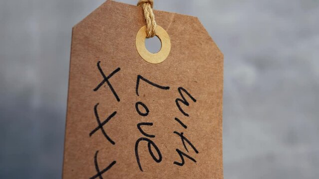 With love handwritten message for gift on gray background 