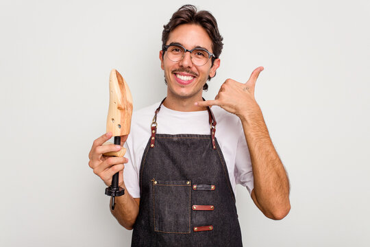 Young hispanic shoemaker isolated on white background showing a mobile phone call gesture with fingers.
