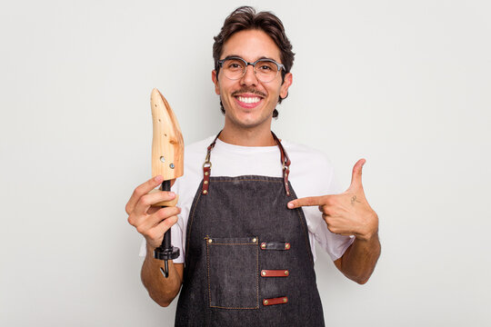 Young hispanic shoemaker isolated on white background person pointing by hand to a shirt copy space, proud and confident