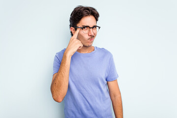 Young hispanic man isolated on blue background pointing temple with finger, thinking, focused on a task.